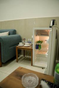 een woonkamer met een bank en een open koelkast bij شقق قلب العاصمة in Bagdad