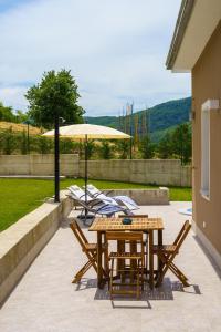 a patio with a table and chairs and an umbrella at Casa Olivieri 05 in San Desiderio
