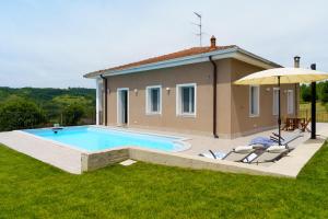 a house with a swimming pool and an umbrella at Casa Olivieri 05 in San Desiderio