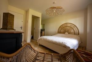 a bedroom with a bed and a chandelier at Gîte les Vabres - Ancienne ferme rénovée piscine pétanque in Coufouleux +25 photos