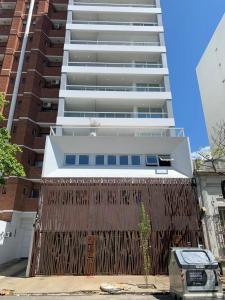 a building with a wooden fence in front of it at Premium Studio, Confort in La Plata