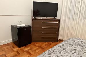 a bedroom with a dresser with a television on it at Independent suite in the center in Pomerode
