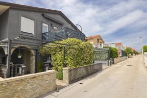 a house with a balcony on a street at Apartmani Vesna in Vir