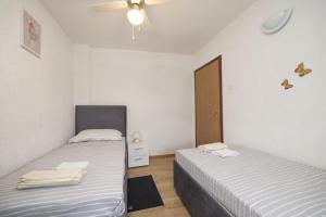 two twin beds in a room with a door at Apartmani Vesna in Vir