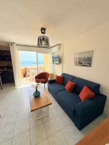 a living room with a blue couch and a table at Panoramic Sea View Chic & Cozy home holiday in Sète