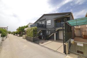 an empty street with a house with a fence at Apartmani Vesna in Vir +14 photos
