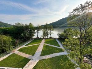 an aerial view of a garden with a lake at Hotel Canudos in Kutaisi