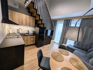a kitchen and a living room with a table and a couch at Apartamenty Premium Gdynia Grabowo 5 in Gdynia