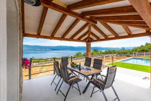a patio with a table and chairs and a view of the water at Vila Mare in Risika