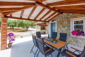 a patio with a wooden table and chairs at Vila Mare in Risika