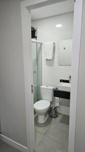 a white bathroom with a toilet and a sink at Lugar Aconchecante 2 Ap 102 in Palhoça +20 photos