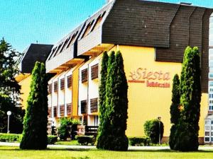 a building with a bunch of trees in front of it at Retai Edit Szieszta in Hajdúszoboszló