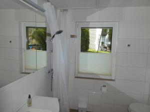 a white bathroom with a toilet and a window at FeWo Ruhe in Olsberg