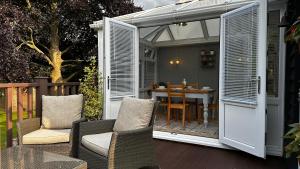a patio with a table and chairs and an open door at Annexe Orchard Cottage in Mersham
