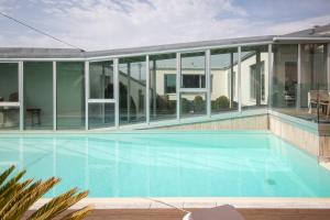 a large swimming pool in a house with glass at AG Villa Razo Luxury en primera linea con piscina in Razo