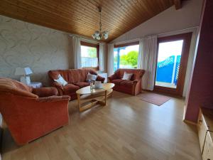 a living room with two couches and a table at Ferienhaus Küstenzauber Simonsberg Nordsee Meer Husum in Simonsberg