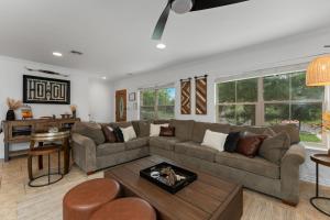 ein Wohnzimmer mit Sofa und Tisch in der Unterkunft Porch & Pour - Hot Tub & Fire Pit in Fredericksburg