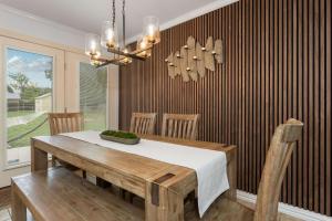 ein Esszimmer mit einem Tisch und einem Kronleuchter in der Unterkunft Porch & Pour - Hot Tub & Fire Pit in Fredericksburg