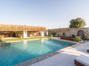 una piscina di fronte a una casa con un edificio di Blanco a Çeşme