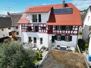 eine Luftansicht eines Hauses mit rotem Dach in der Unterkunft Ferienwohnung Seescheune 150m vom Ufer entfernt in Bodman-Ludwigshafen