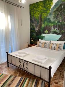 a bedroom with a large bed with a painting on the wall at Casa en la Montaña in Kambitsáta +39 photos