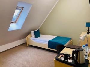 a small room with a bed and a desk at Villa FOREST in Poznań