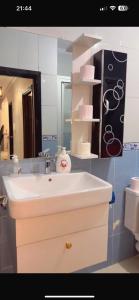 a bathroom with a white sink and a mirror at Appartement Tanger familles in Tangier