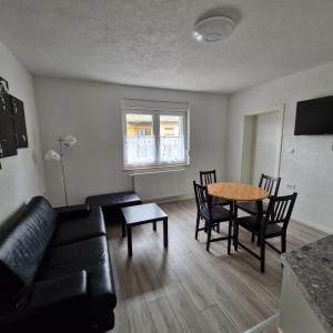 a living room with a black couch and a table at Villa Natasa near Plitvice for 15 persons in Vrhovine