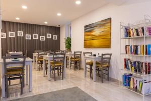 a dining room with tables and chairs and bookshelves at Roel Boutique B&B in Cospicua