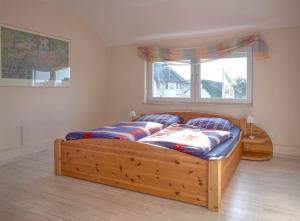 a bedroom with a wooden bed with a window at Ferienwohnung Relax nähe Herzzentrum in Bad Oeynhausen