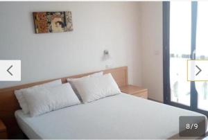 a white bed with two pillows in a bedroom at Casetta al mare in Cupra Marittima
