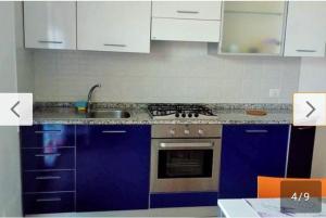 a kitchen with blue cabinets and a stove top oven at Casetta al mare in Cupra Marittima