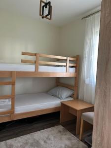 a room with two bunk beds and a table at Kuća Pod Brezama in Tabanović