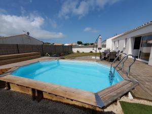 a pool with a wooden deck and a swimming poolitures at Les pivoines Notre-Dame-de-Monts in Notre-Dame-de-Monts