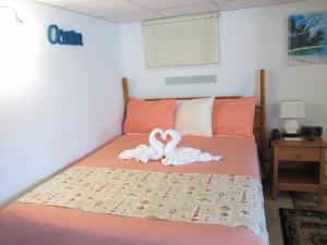 a white teddy bear sitting on top of a bed at Green Dolphin Motel in Old Orchard Beach