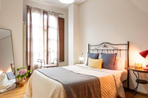a bedroom with a bed with orange and blue pillows at Apartamento Las Cruces 3 in Gijón