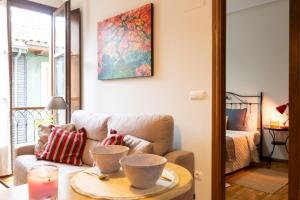a living room with a couch and a table with a candle at Apartamento Las Cruces 3 in Gijón +14 photos