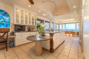 een grote keuken met een tafel en een eetkamer bij Spectacular Oceanfront Home - Honu Hale in Kahana