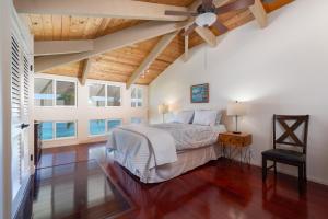 een slaapkamer met een bed en een plafondventilator bij Spectacular Oceanfront Home - Honu Hale in Kahana +31 foto's