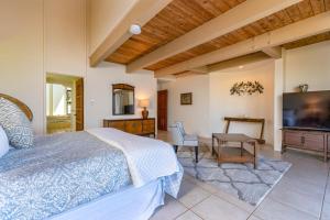 een slaapkamer met een bed en een flatscreen-tv bij Spectacular Oceanfront Home - Honu Hale in Kahana