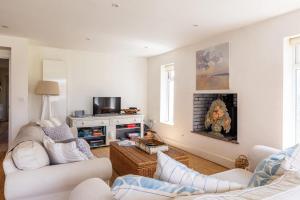 a living room with two couches and a fireplace at 5 Bedroom Family Friendly Beach House - a skip to the water! in West Wittering