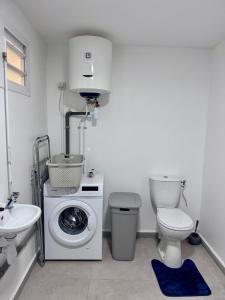 a bathroom with a washing machine and a toilet at Cocon du Souffleur in Port-Louis +14 photos