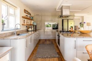 a kitchen with white cabinets and a sink at 5 Bedroom Family Friendly Beach House - a skip to the water! in West Wittering +41 photos