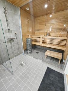 e bagno con doccia, panca e vasca. di Heim Apartments - Rivitalo a Seinäjoki
