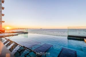 ein Schwimmbad mit Strand im Hintergrund in der Unterkunft Estúdios em Prédio Beira-Mar, prox. ao beto Carreiro no Penha Spot - PSOB in Gravata