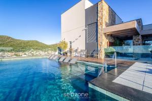 ein Swimmingpool vor einem Haus in der Unterkunft Estúdios em Prédio Beira-Mar, prox. ao beto Carreiro no Penha Spot - PSOB in Gravata