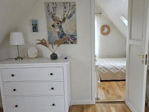 a white dresser in a room with a bedroom at Pond View Cabin in Būda