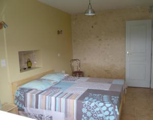 een slaapkamer met een bed in een kamer bij La grange in Saint-Germain-de-Lusignan +1 foto
