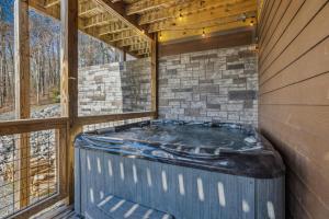 a hot tub in the corner of a house with windows at Wild Heart Lodge cabin in Sevierville
