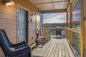 a porch with chairs and a grill on a house at Wild Heart Lodge cabin in Sevierville